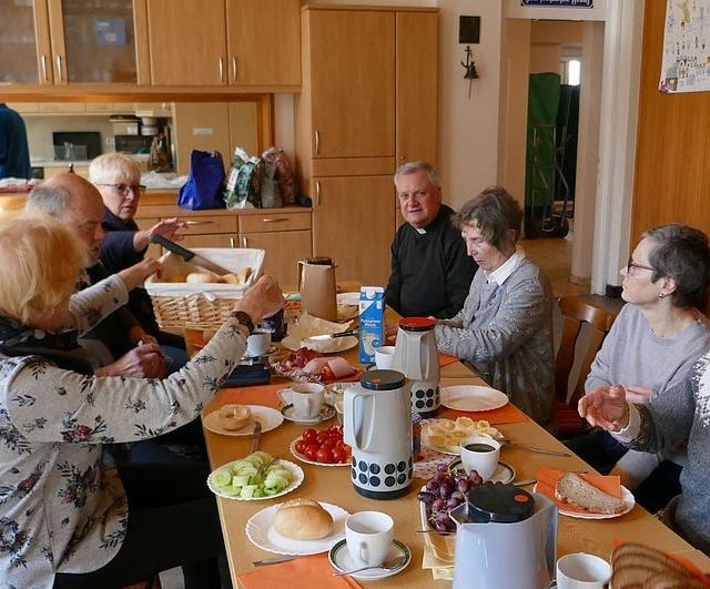 Koplingsfamilie sitzt zum Essen zusammen