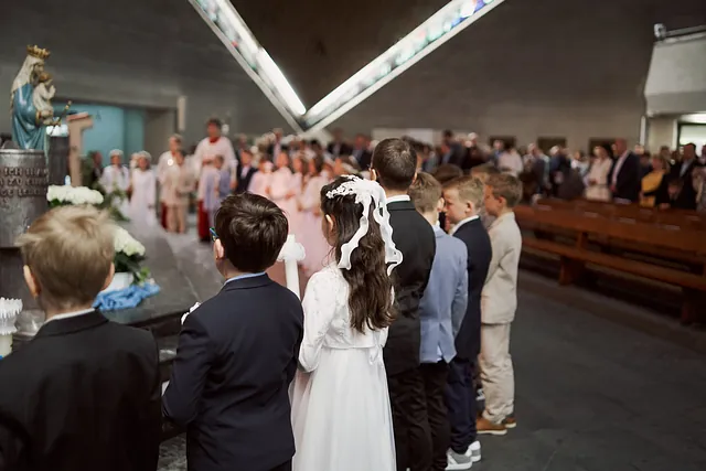 Erstkommunion-Kinder stehen versammelt am Altar in der Kirche Maria Frieden